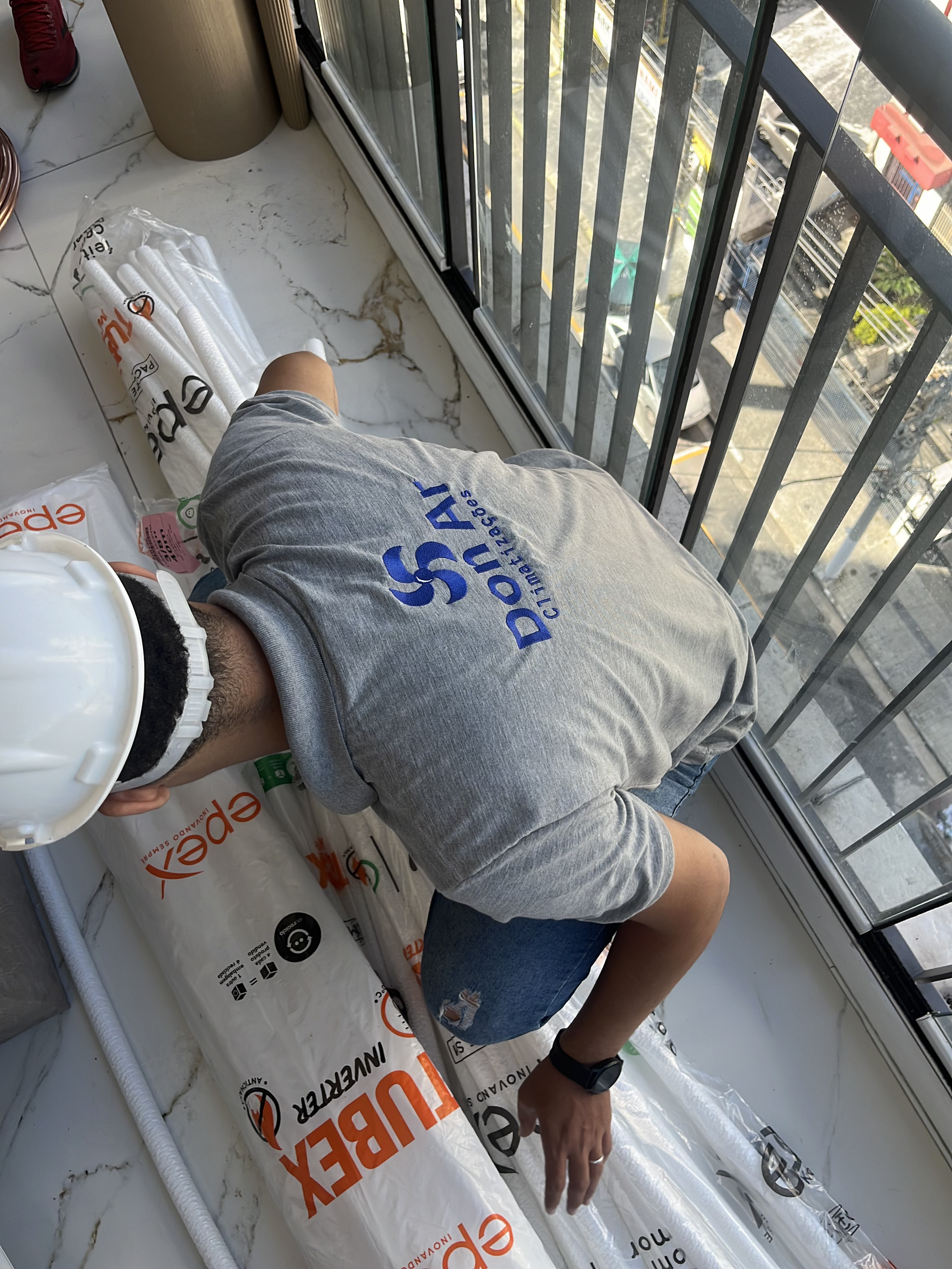 Profissional da Don Ar preparando a infraestrutura de uma instalação em varanda residencial