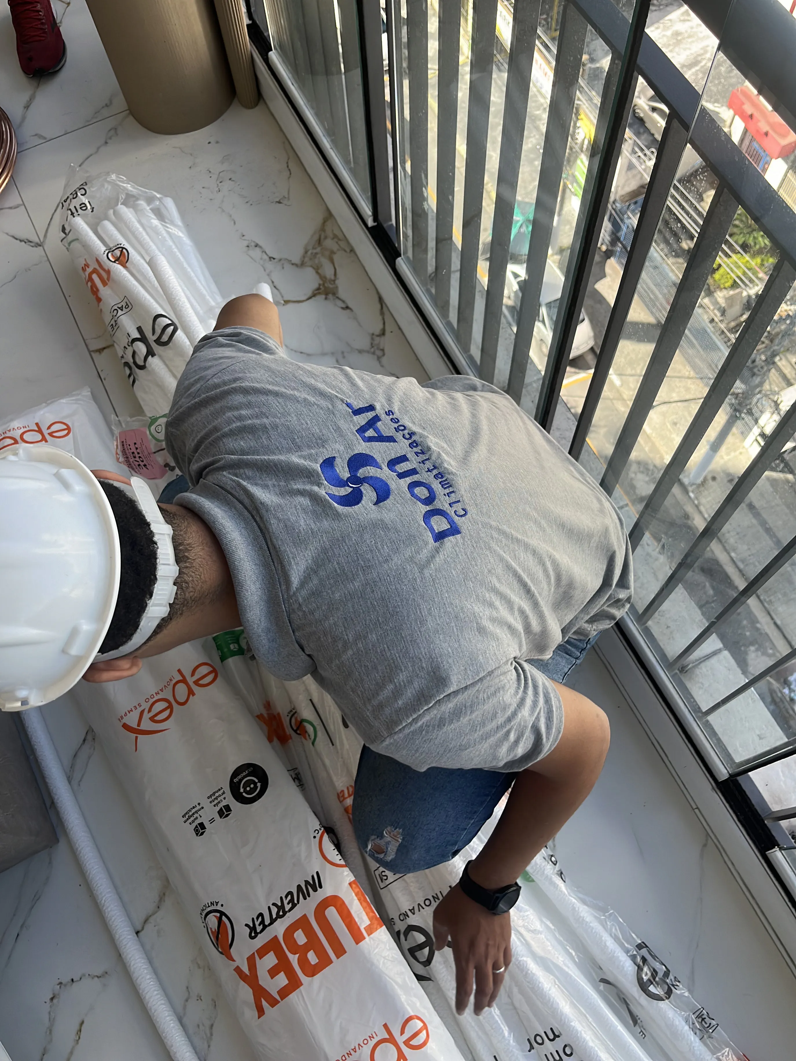 Profissional da Don Ar preparando a infraestrutura de uma instalação em varanda residencial