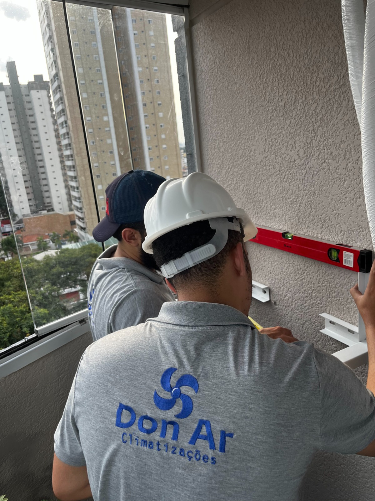 Equipe da Don Ar realizando a marcação e preparação de uma instalação em varanda